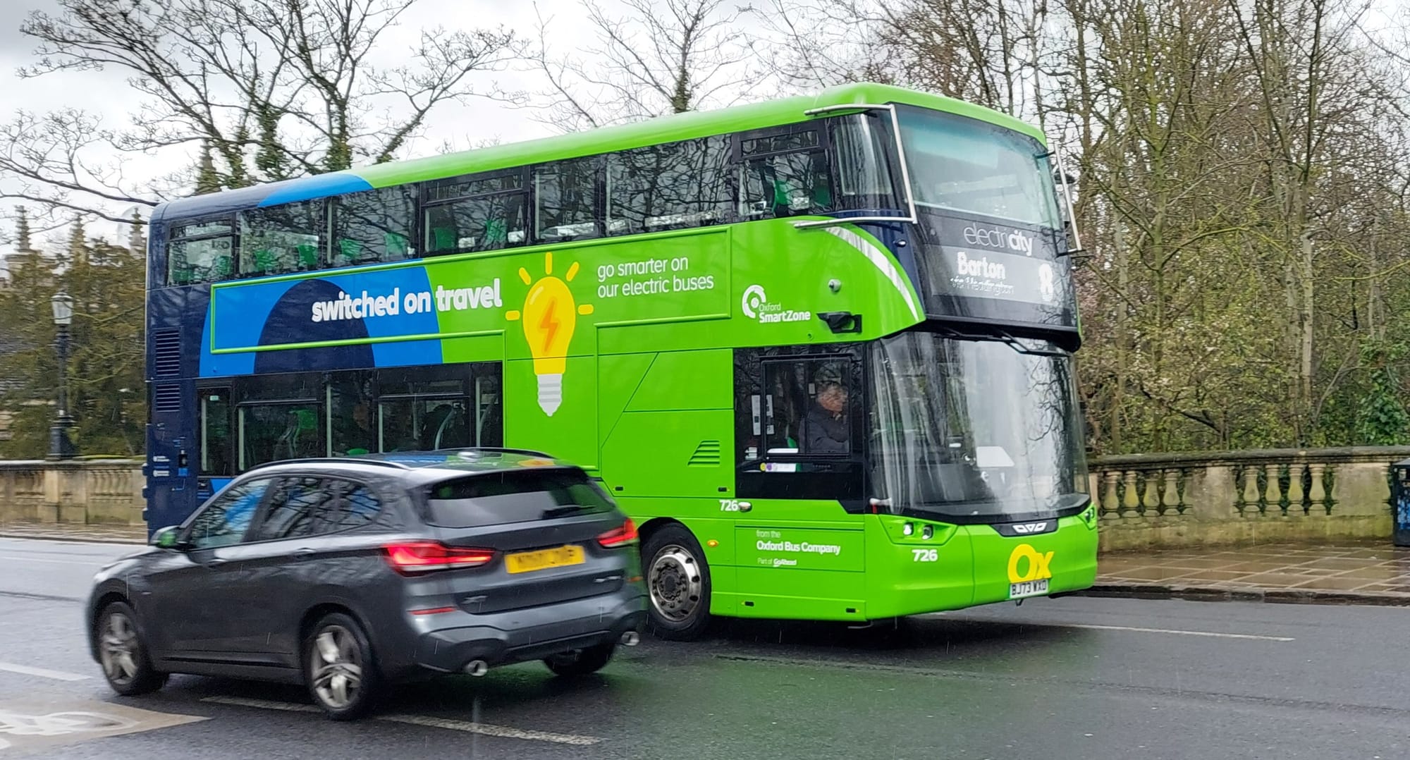 A private car (5 seats) and an electric bus (74 seats) passing on Magdalen Bridge, Oxford