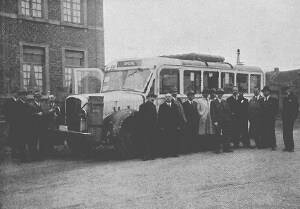 A black-and-white photo of an old-fashioned bus surrounded by old-fashioned people. We note that they weren't old-fashioned in 1943.