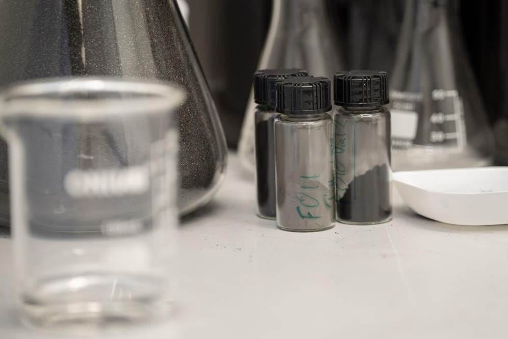 Close-up of several small bottles containing a black powder