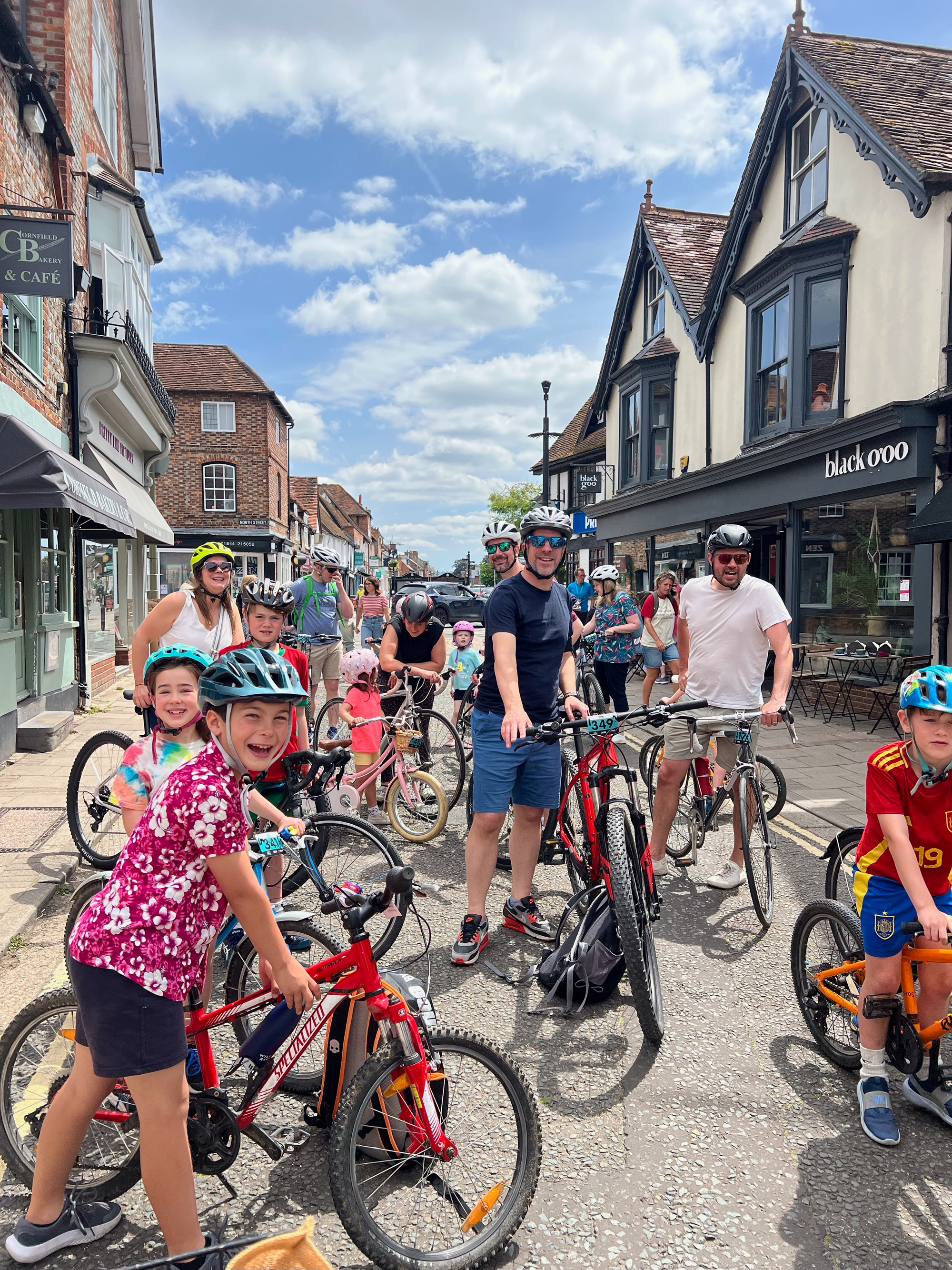 Many children and some adults with bikes cheerfully ready to get started on their ride