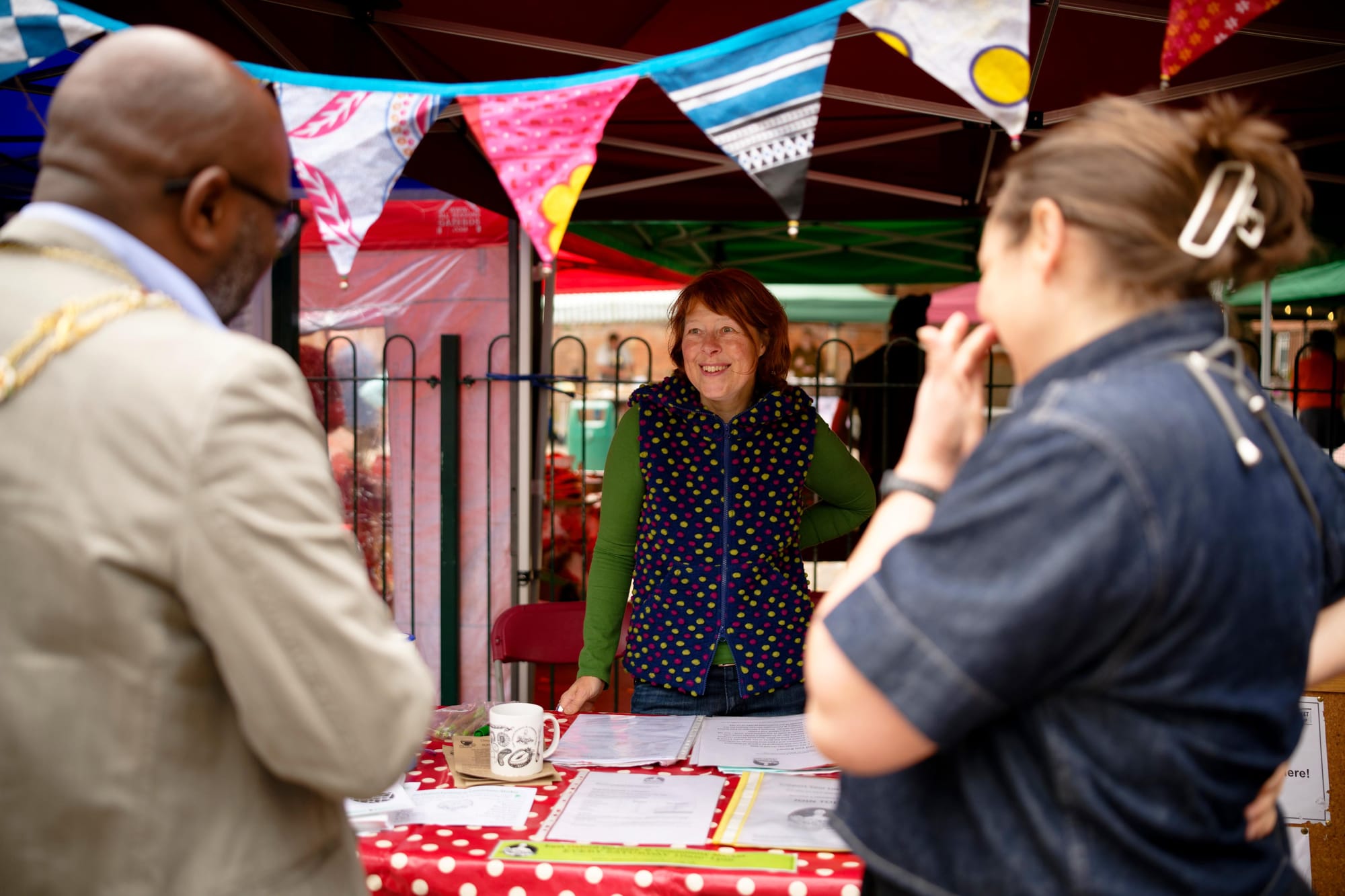Smiling woman behind stall with bunting on top