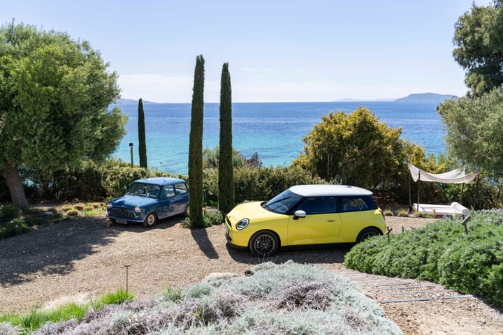 A big yellow new Mini a blue classic mini, on holiday together in the Mediterranean. 