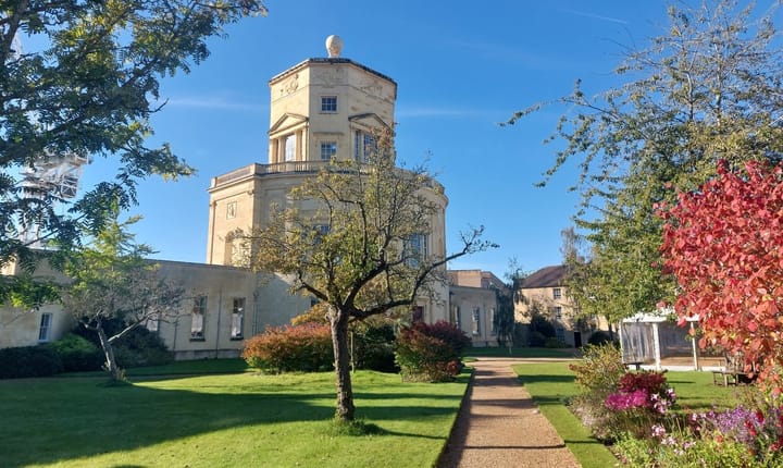 A tall building in well kept a garden